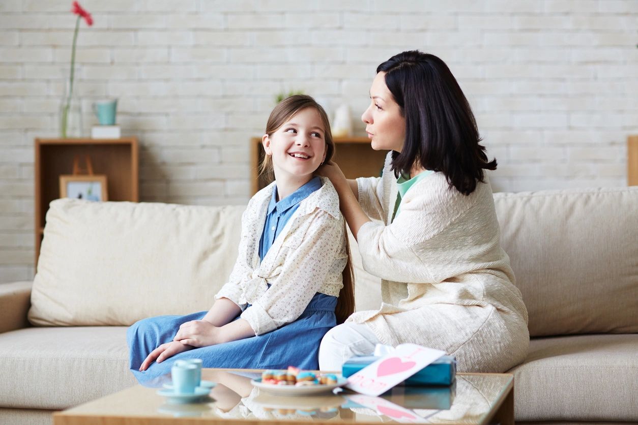 Happy woman talking to her teenage daughter at home